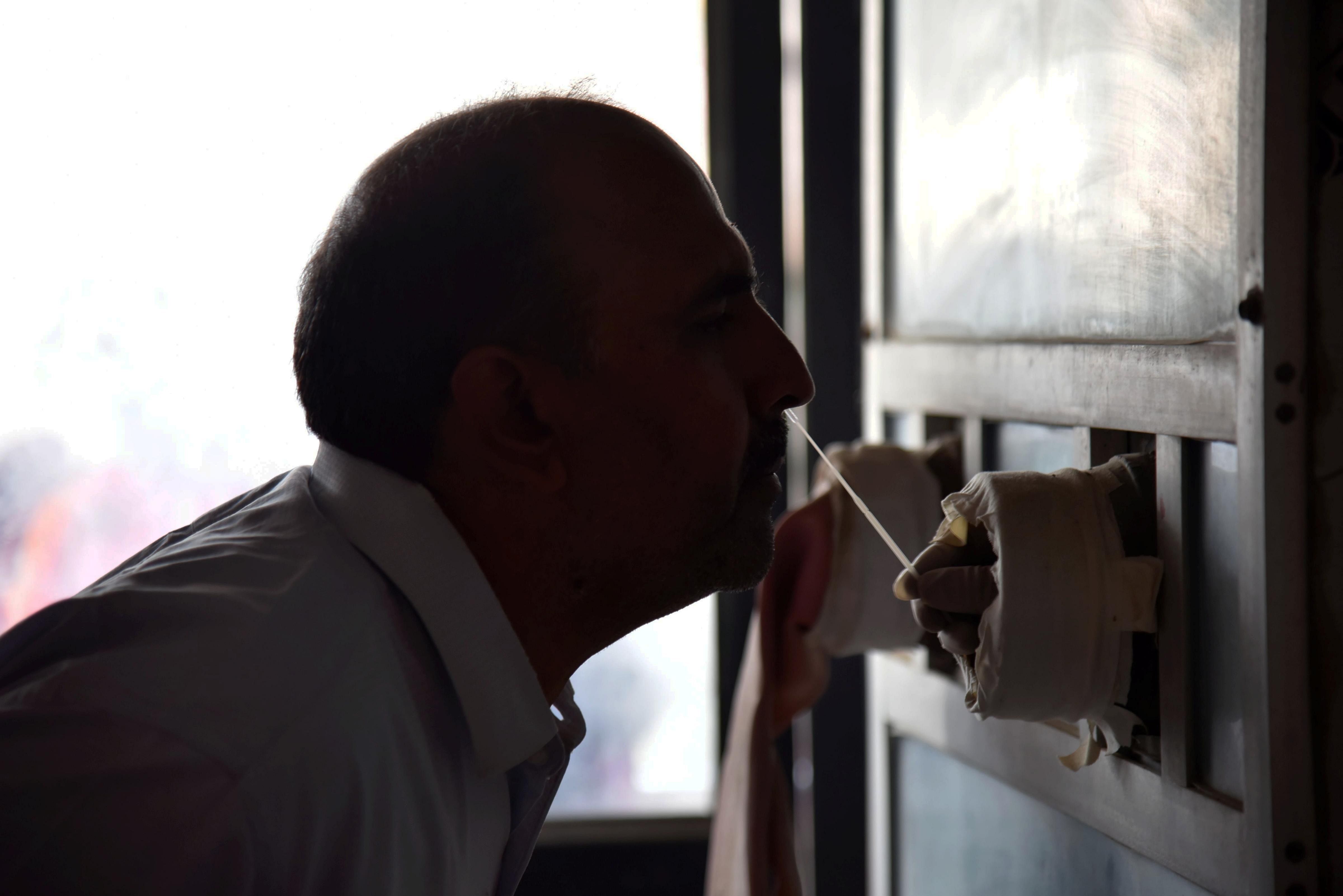 A health worker collects swab for Covid-19 test following the rise in coronavirus cases. Credit: PTI Photo