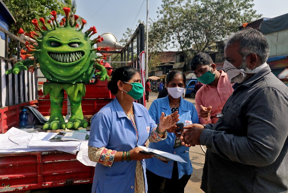 (COVID-19) in Mumbai  Volunteers distribute pamphlets during an awareness campaign on the spread of the coronavirus disease (COVID-19) on a street in Mumbai, India, February 22, 2021. Credit: REUTERS Photo