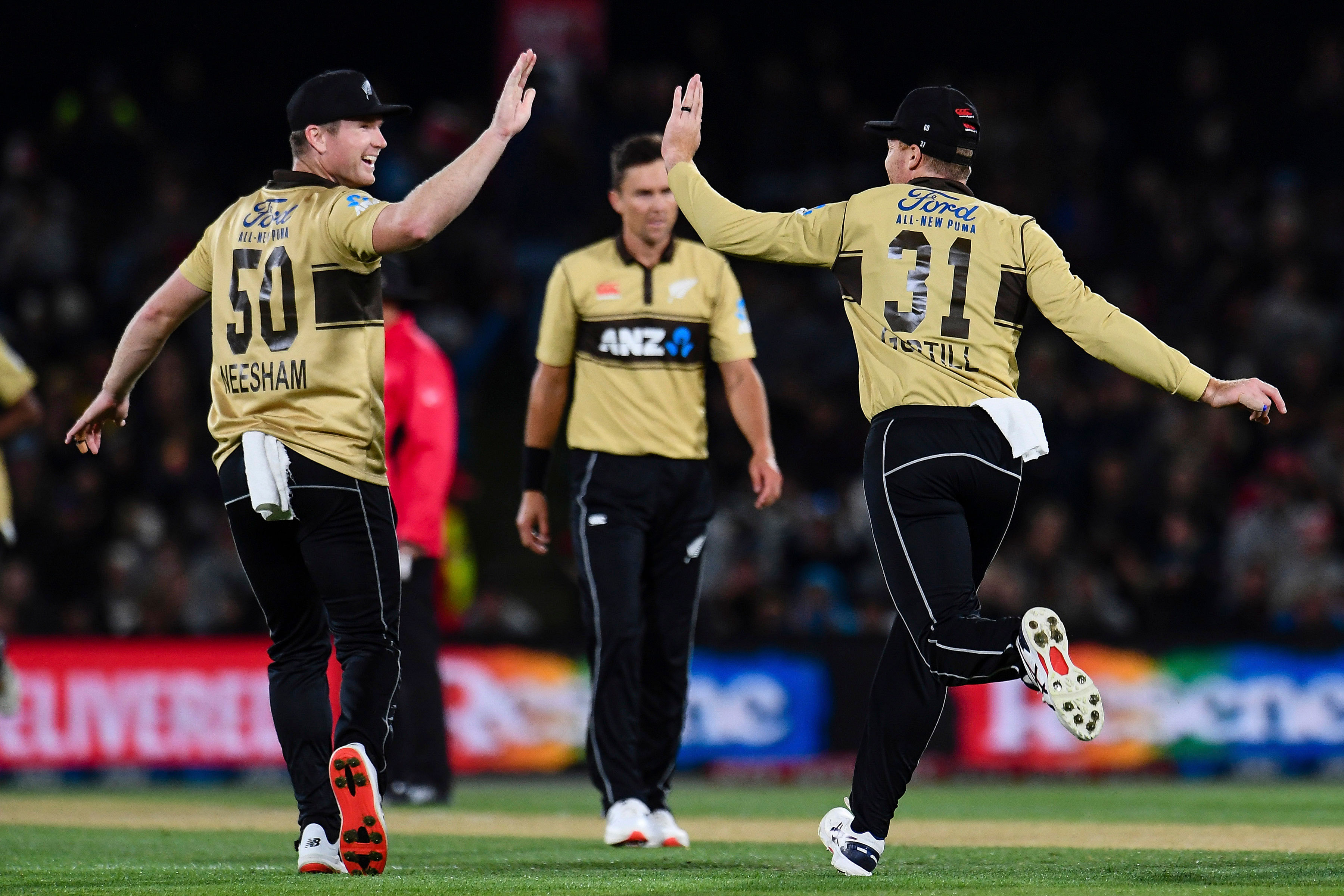 New Zealand's James Neesham, left, and Martin Guptill celebrate the wicket of Australia's Matthew Wade during the first T20 cricket international between Australia and New Zealand at Hagley Oval in Christchurch, New Zealand, Monday, Feb. 22, 2021. Credit: AP/PTI Photo