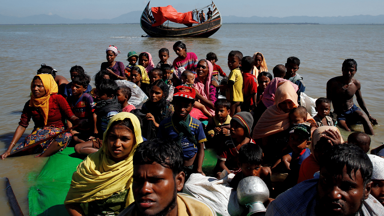 Rohingya refugees sit on a makeshift boat as they get interrogated by the Border Guard Bangladesh after crossing the Bangladesh-Myanmar border, at Shah Porir Dwip near Cox's Bazar. Credit: Reuters Photo