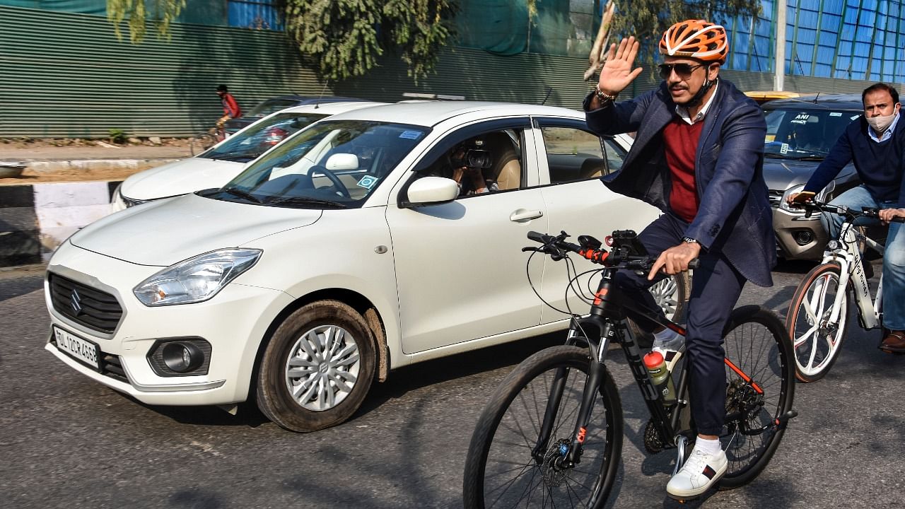 Businessman Robert Vadra rides a bicycle on his way to his office during a protest against the hike in fuel price, in New Delhi. Credit: PTI Photo