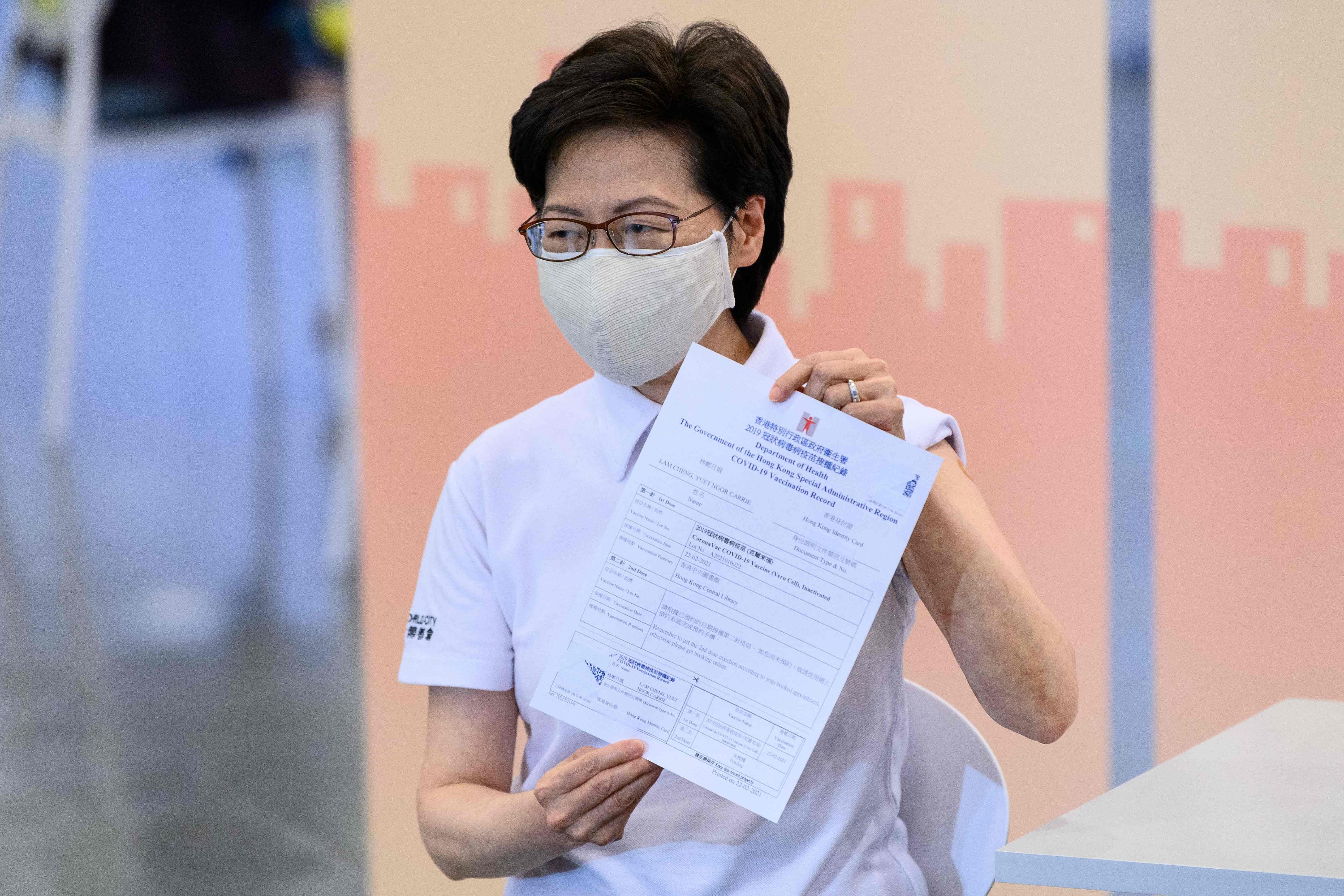 Hong Kong's Chief Executive Carrie Lam holds up a certificate after receiving China's Sinovac COVID-19 coronavirus vaccine at the Community Vaccination Centre in Hong Kong on February 22, 2021. Credit: AFP Photo