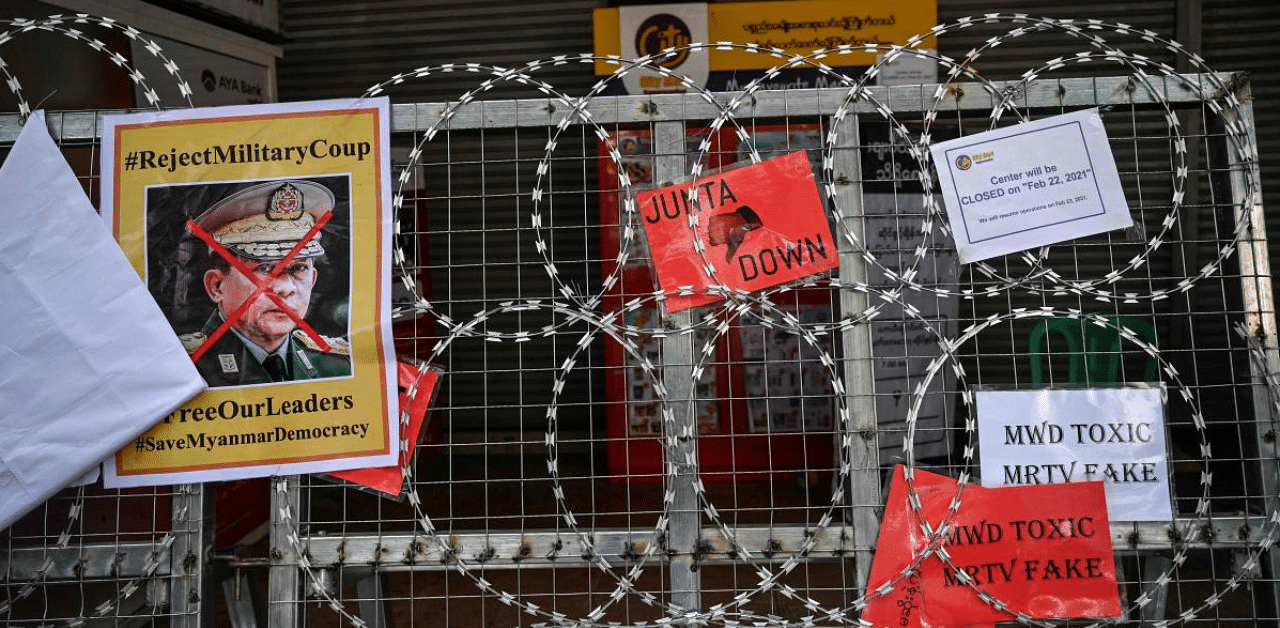 A sign denouncing Myanmar military chief General Min Aung Hlaing is pictured on barbed wire as protesters take part in a demonstration against the military coup in Yangon. Credit: AFP Photo