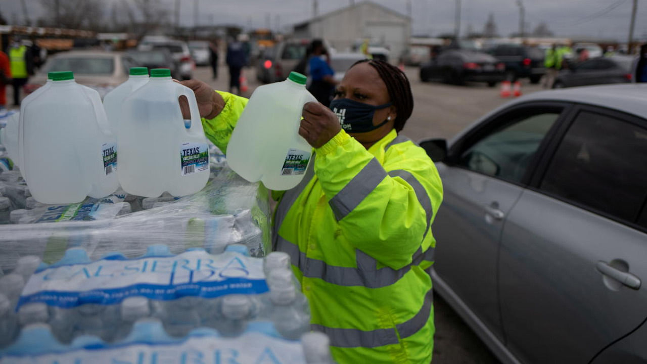 Volunteer Elizabeth Murray helps hand water to local residents at Butler Stadium after the city of Houston implemented a boil water advisory following an unprecedented winter storm in Houston, Texas. Credit: Reuters.