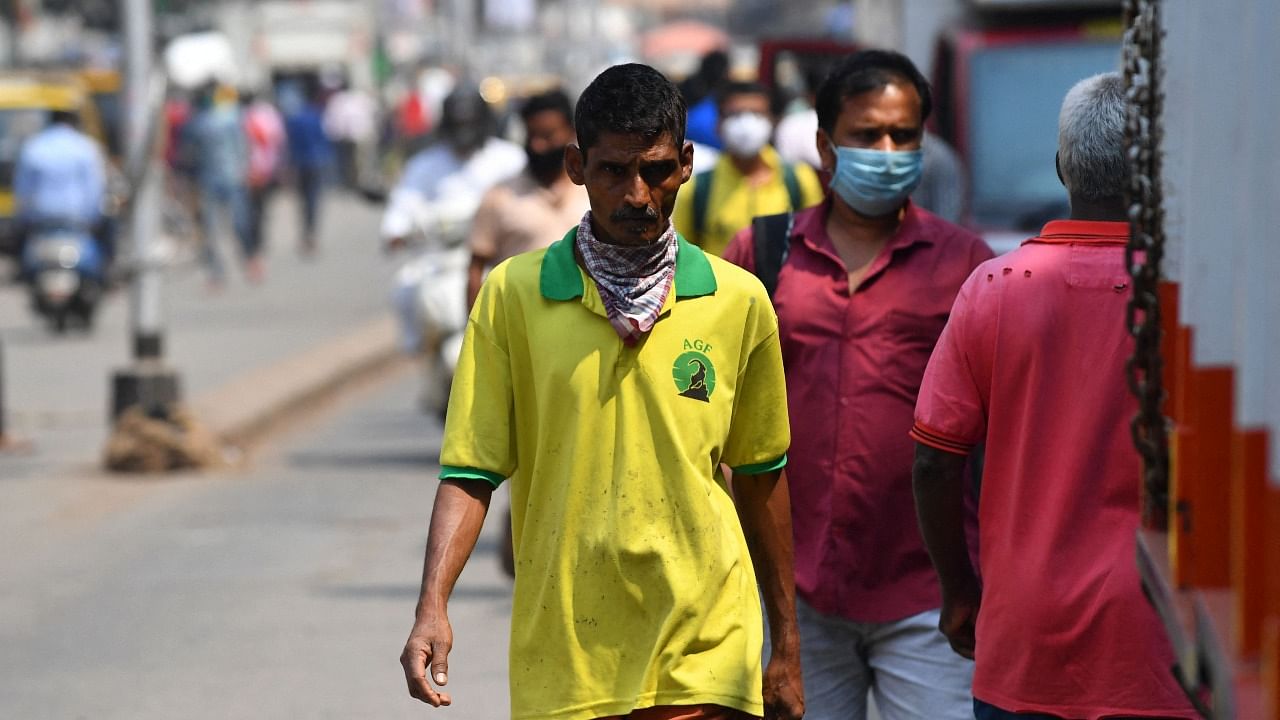 A pedestrian walks along a road without wearing a face mask despite restrictions imposed as a preventive measure against the spread of the Covid-19 coronavirus, in Mumbai on February 23, 2021. Credit: AFP Photo