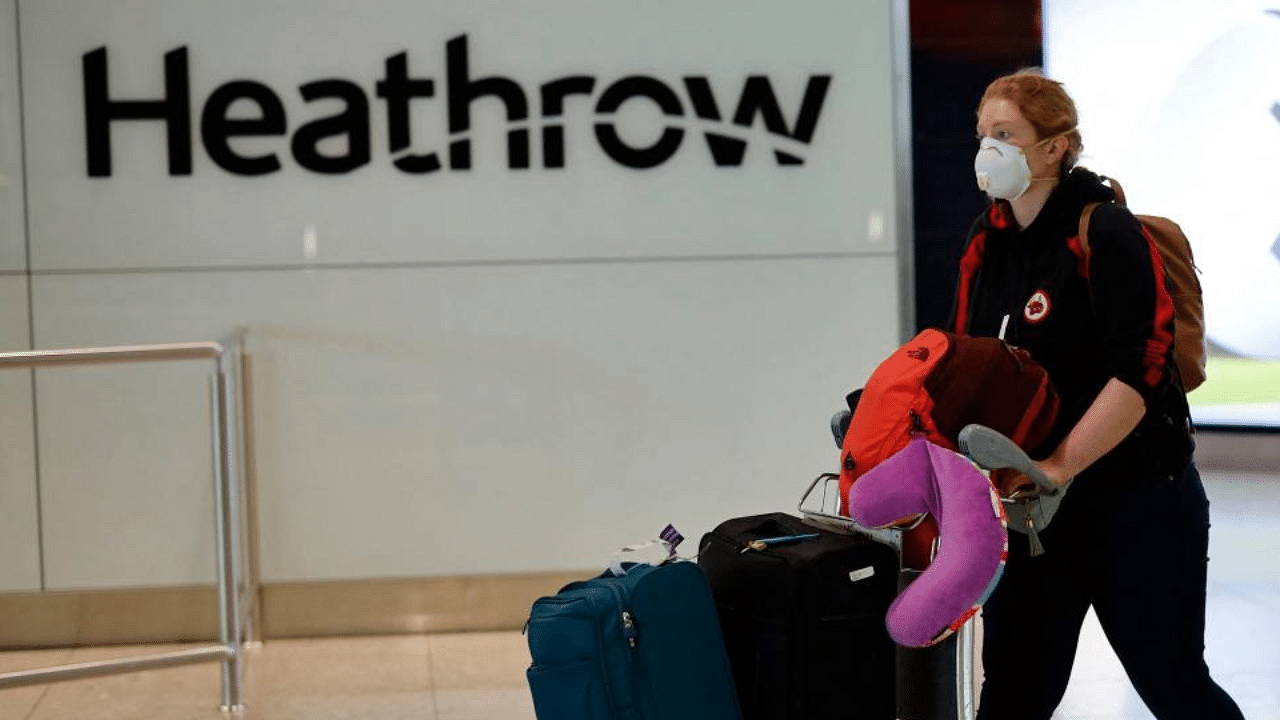 A passenger wearing PPE (personal protective equipment) arrives at Terminal 2 of Heathrow airport, west London. Credit: AFP File Photo