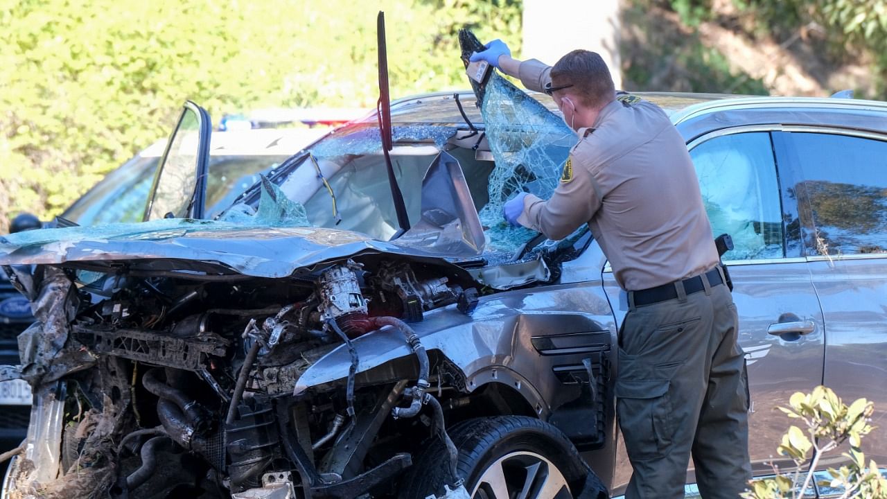 A law enforcement officer looks over a damaged vehicle following a rollover accident involving golfer Tiger Woods, Tuesday, February 23, 2021, in the Rancho Palos Verdes section of Los Angeles. Credit: AP/PTI Phtoo