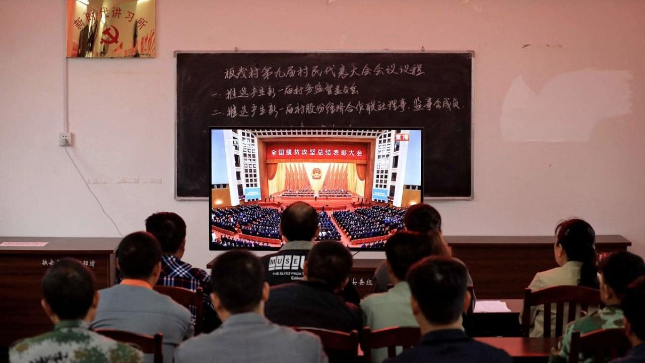 People watch a livestream of the ceremony to mark the country's accomplishments in poverty eradication after Chinese President Xi Jinping declared his country had achieved the "human miracle" of eliminating extreme poverty, at a village in liuzhou, in southern China's Guangxi province. Credit: AFP.