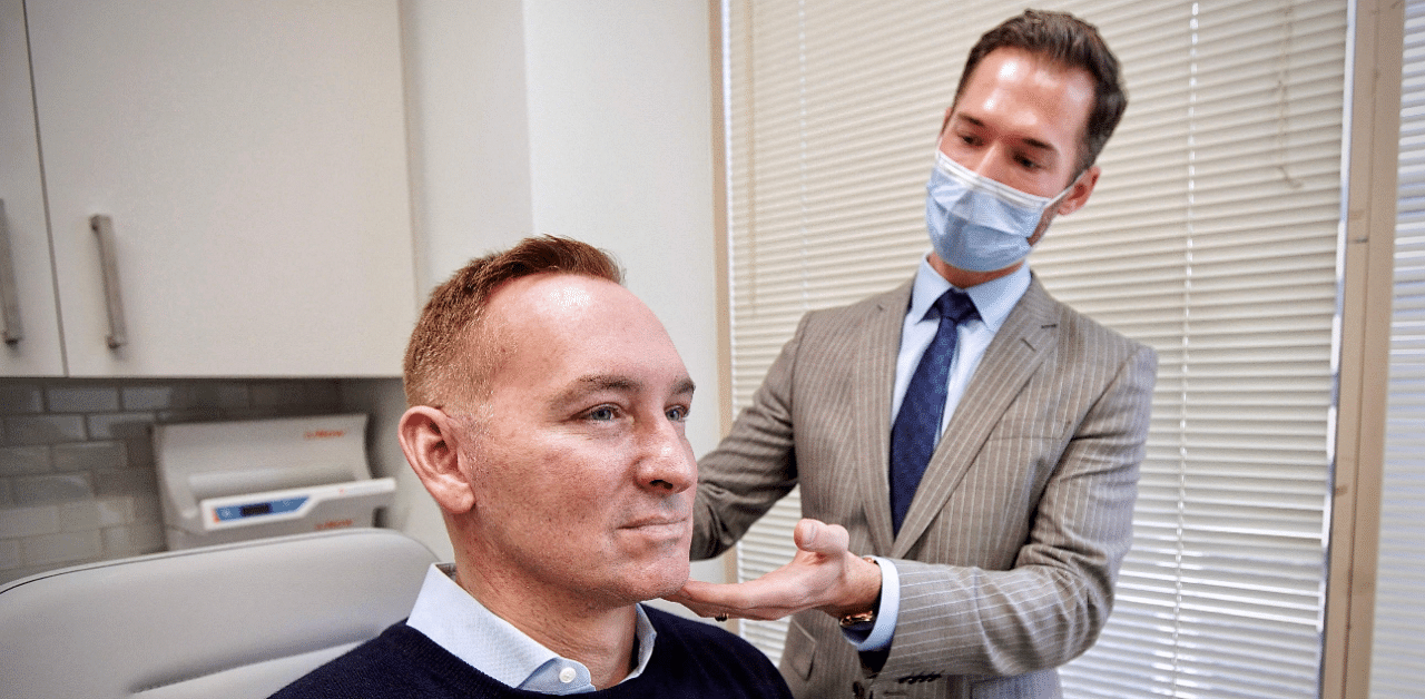 Plastic surgeon Dr. Michael Somenek examines the face of his patient Hudson Young. Credit: AFP Photo