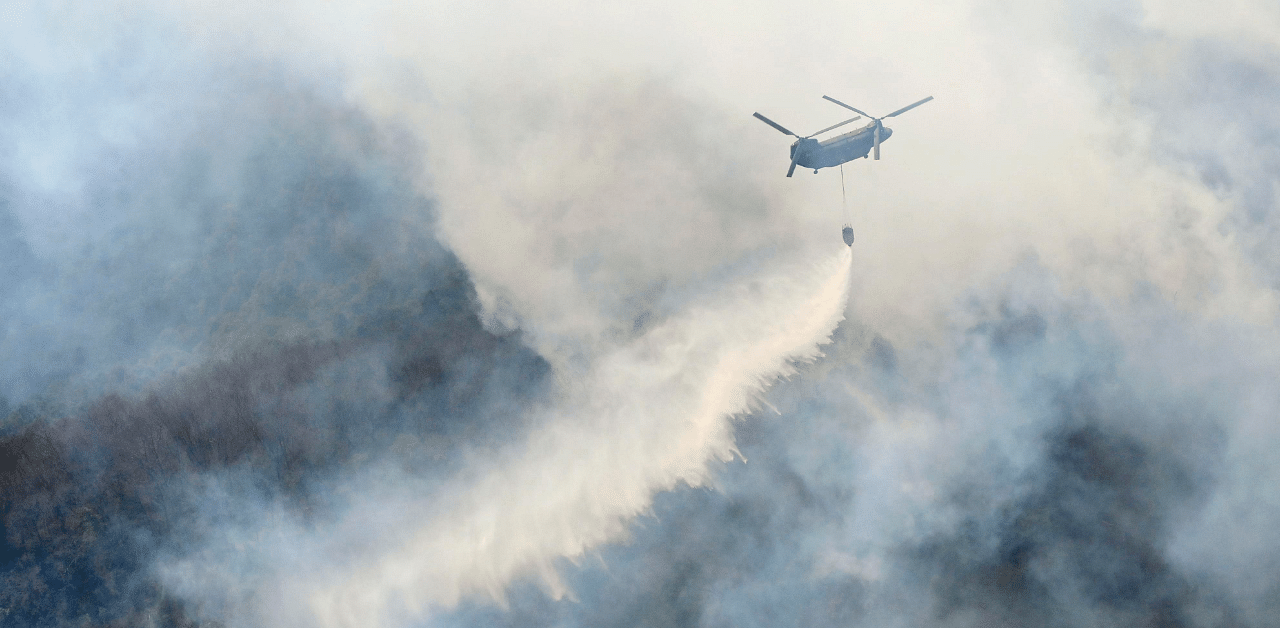 A helicopter dumps water on a wildfire in Ashikaga, Tochigi prefecture, north of Tokyo Wednesday. Credit: AP Photo