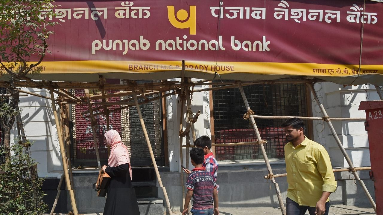 People walk past as CBI team seals Punjab National Bank’s South Mumbai branch at Brady House in Mumbai on Monday. The PNB fraud case involving jeweller Nirav Modi was allegedly carried out of this branch. Credit: PTI File Photo