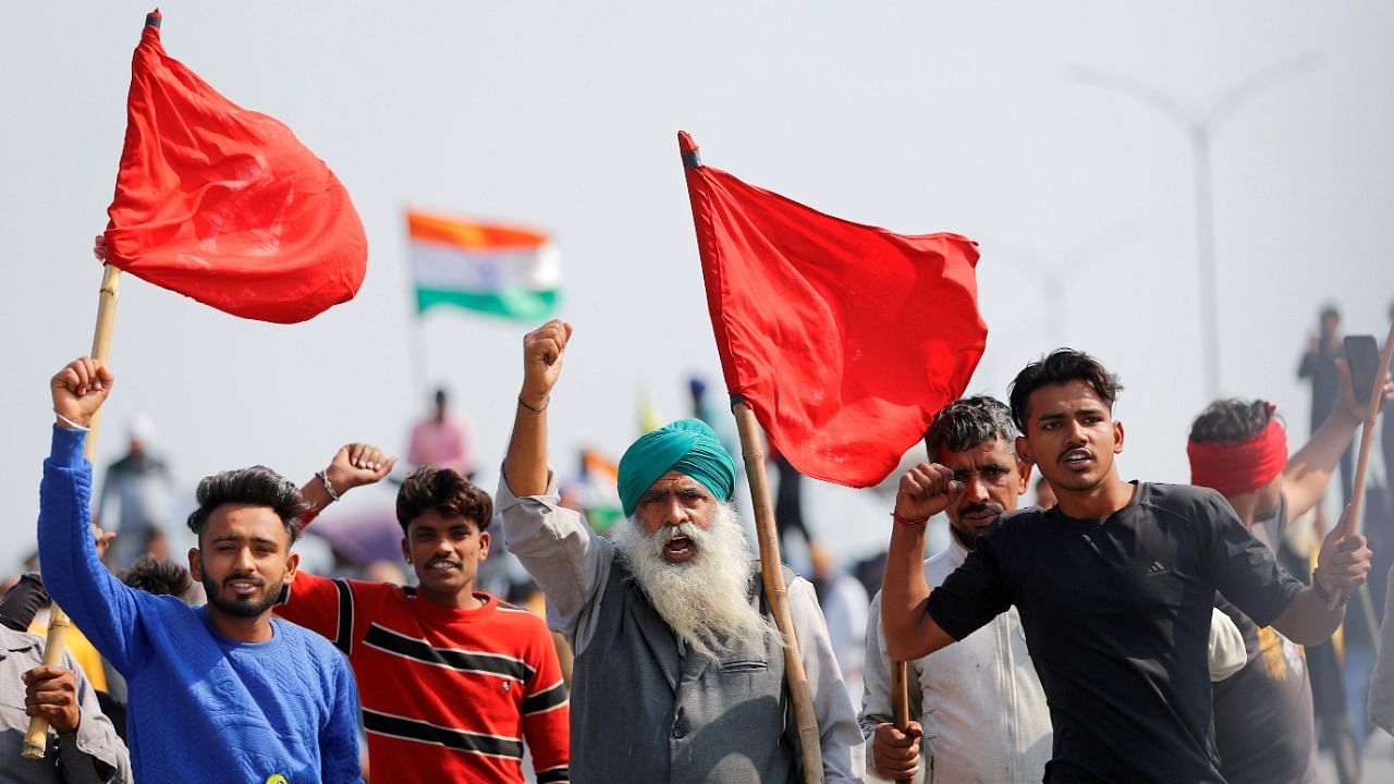 Farmers shout slogans as they take part in a three-hour "chakka jam" or road blockade, as part of protests against farm laws on a highway on the outskirts of New Delhi, India. Credit: Reuters File Photo