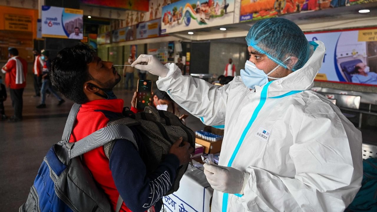 A medical worker takes a swab sample from a passenger for a Rapid Antigen Test (RAT) Covid-19 coronavirus test at the railway station in New Delhi on February 25, 2021. Credit: AFP Photo