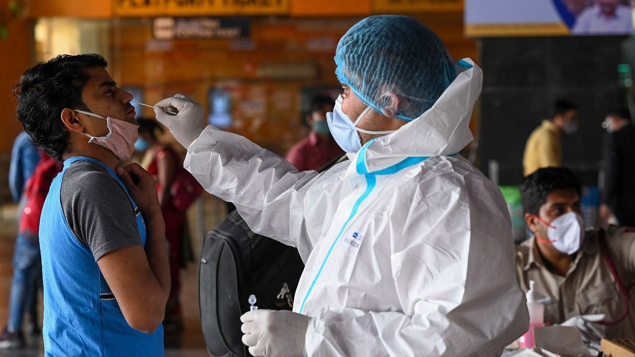 A medical worker takes a swab sample from a passenger for a Rapid Antigen Test (RAT) Covid-19 coronavirus test. Credit: AFP File Photo