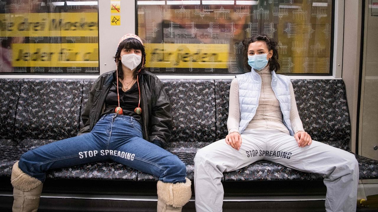 Elena Buscaino (right) and Mina Bonakdar pose with their Riot Pants with the lettering "Stop Spreading" in a subway on February 5, 2021 in Berlin. Credit: AFP Photo