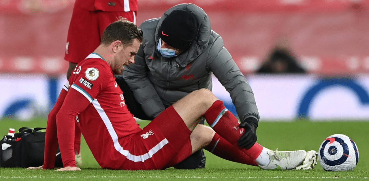 Liverpool's Jordan Henderson receives medical attention after sustaining an injury. Credit: Reuters Photo