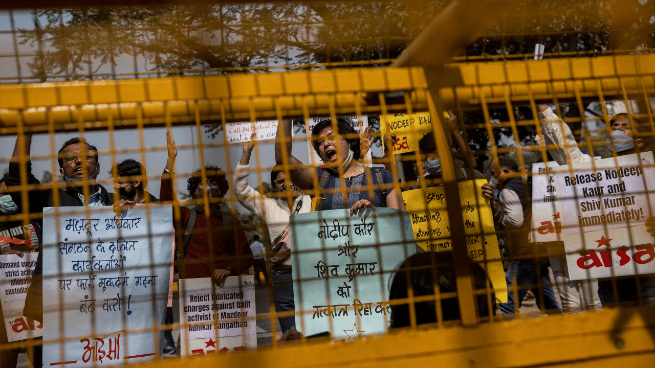 Demonstrators shout slogans behind police barricades during a protest demanding the release of social activists who, according to them, were arrested by the police for supporting farmers' protest against farm laws, in New Delhi. Credit: Reuters Photo