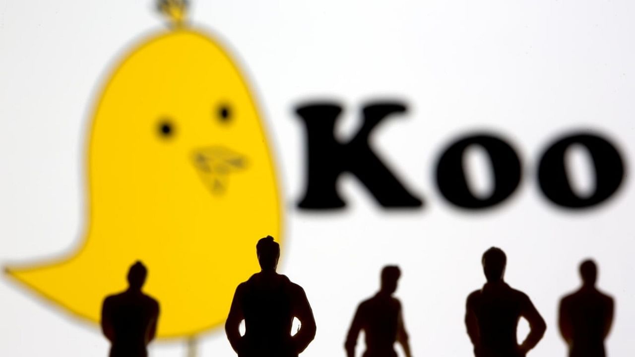 Small toy figures are seen in front of displayed Koo app logo in this illustration. Credit: Reuters.