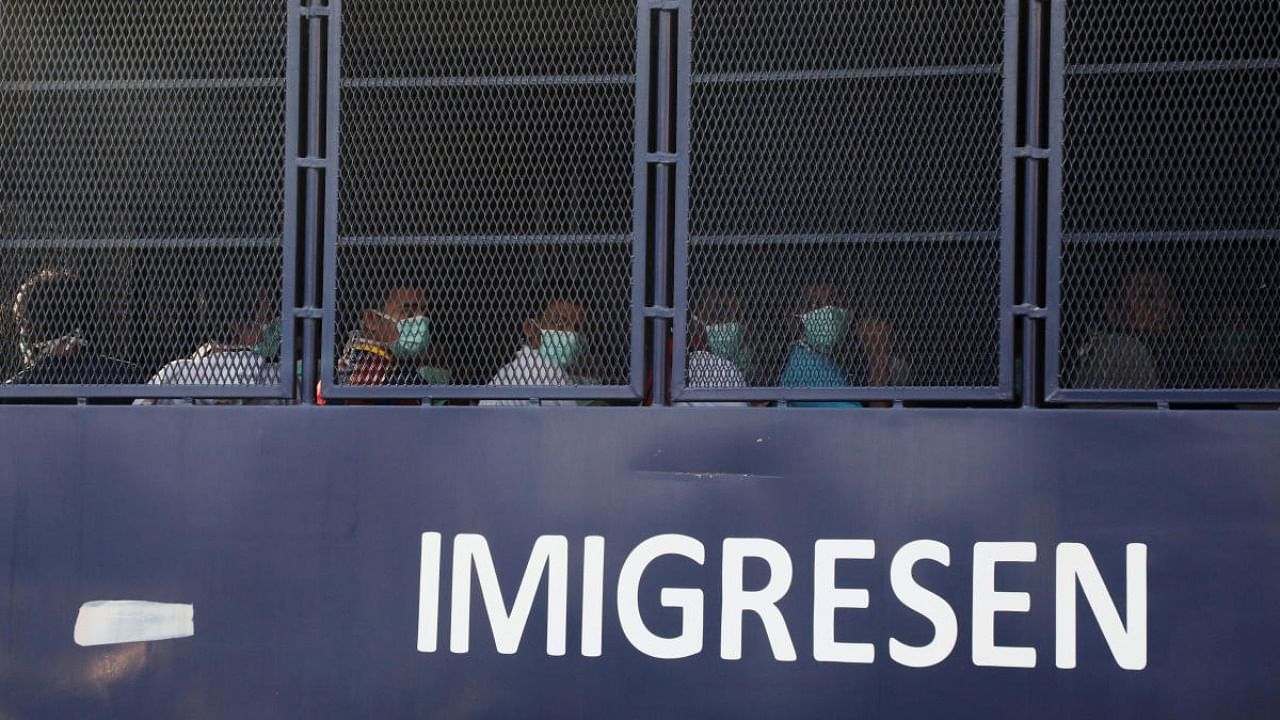 Myanmar migrants to be deported from Malaysia are seen inside an immigration truck, in Lumut, Malaysia. Credit: Reuters file photo.