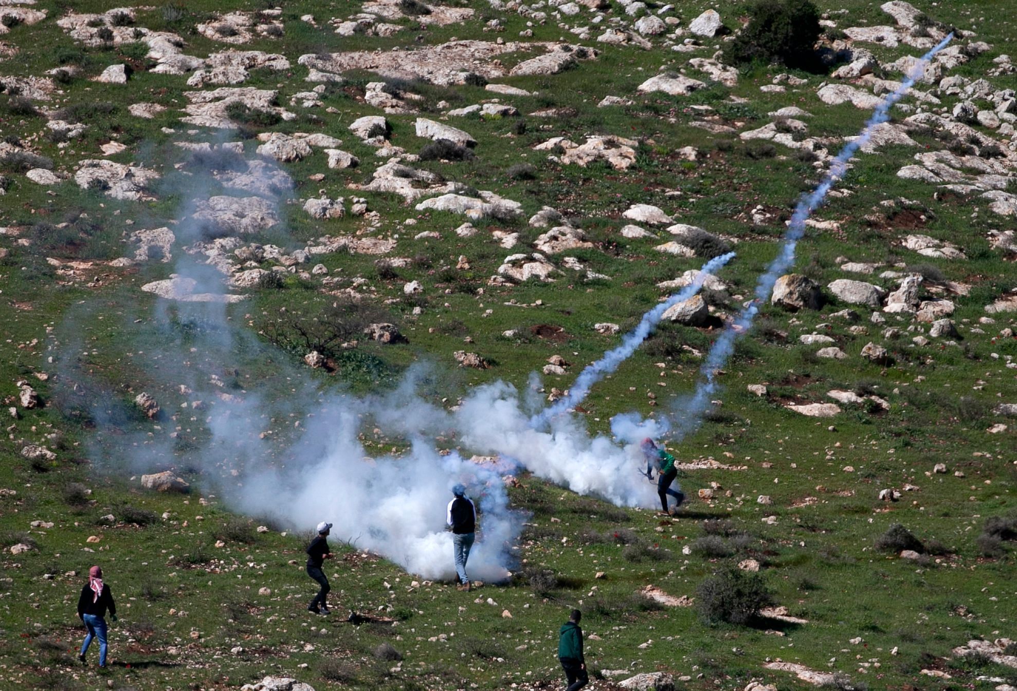 Children from the village of Beit Dajan, east of Nablus, hurl rocks at Israeli soldiers during a protest against the establishment of a settlement outpost on the lands of the village, on February 26, 2021. Credit: AFP Photo