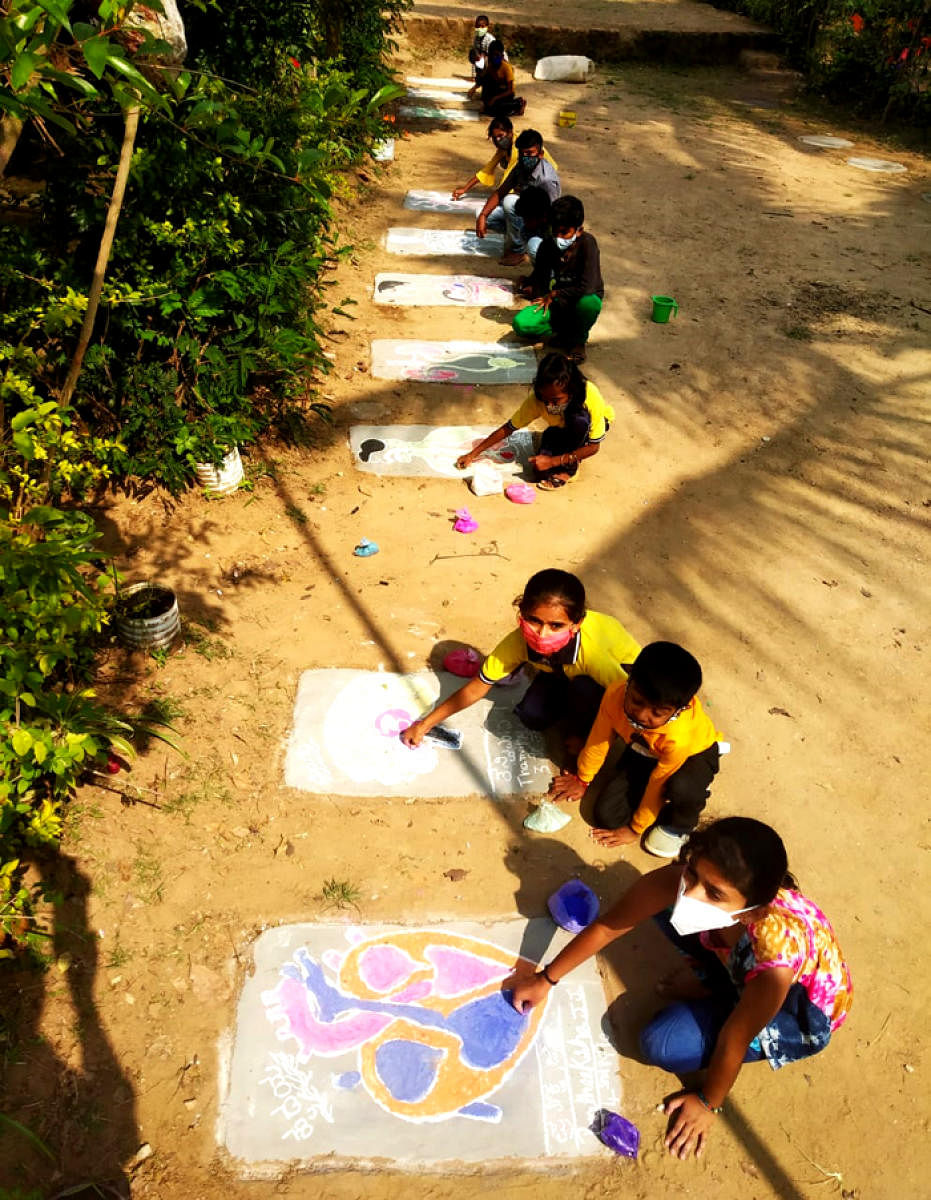 Children draw science models using rangoli powder at Government Lower Primary School in Mullur.