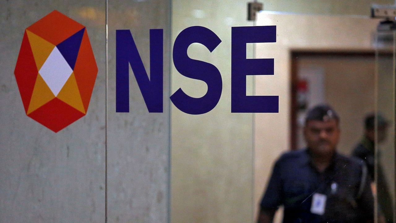 A security guard walks past the logo of the National Stock Exchange inside its building in Mumbai. Credit: Reuters Photo
