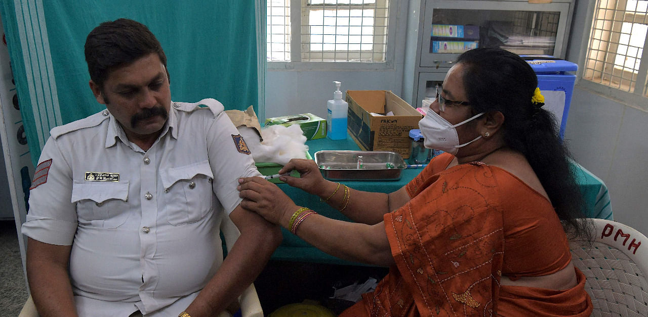 A medical worker inoculates a traffic policeman with a Covid-19 vaccine at a hospital in Bengaluru. Credit: AFP Photo