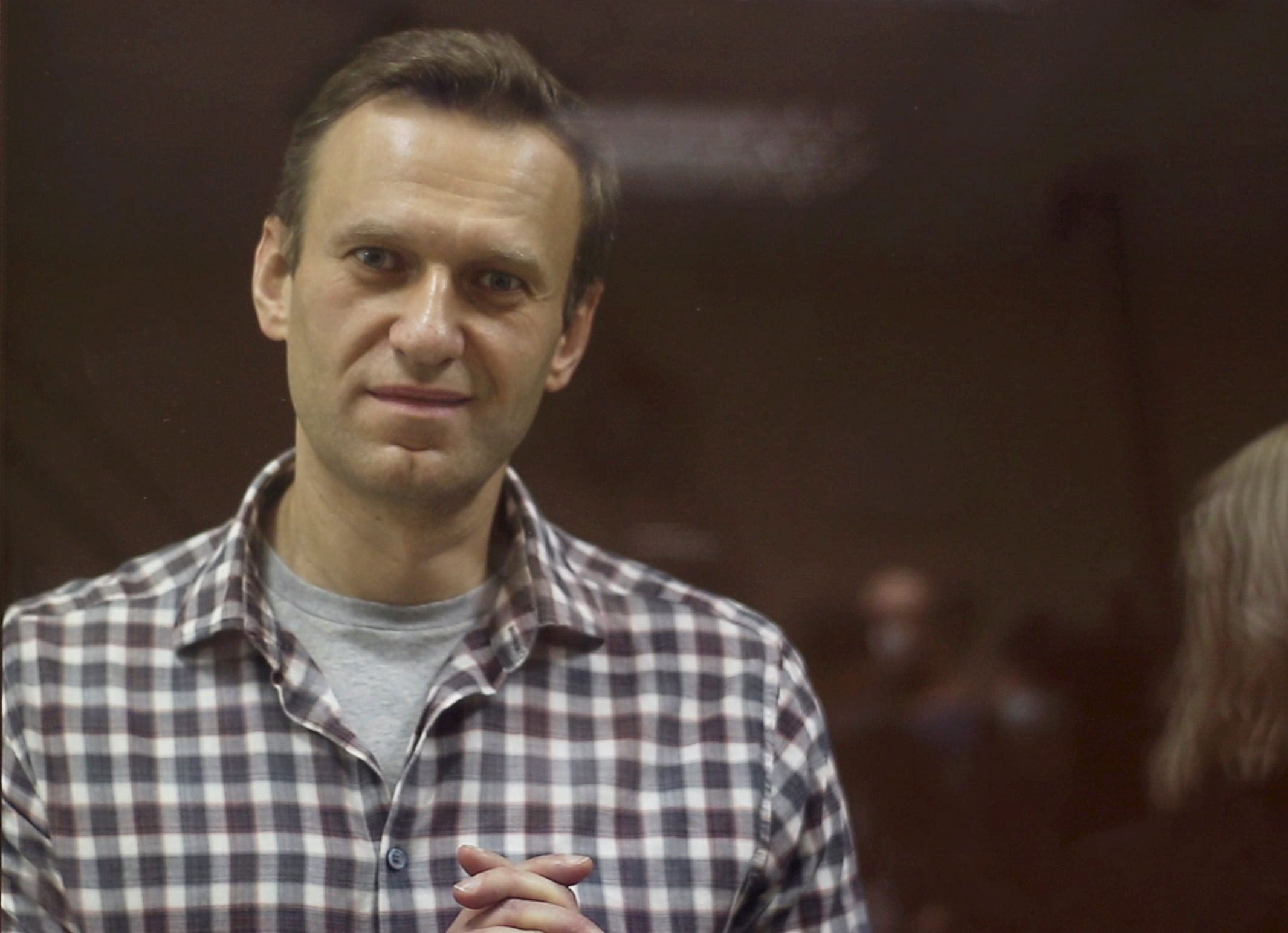  Kremlin critic Alexei Navalny, who is accused of slandering a Russian World War Two veteran, stands inside a defendant dock during a court hearing in Moscow, Russia, Russia February 20, 2021, in this still image taken from video. Credit: Babushkinsky District Court of Moscow/Handout via REUTERS