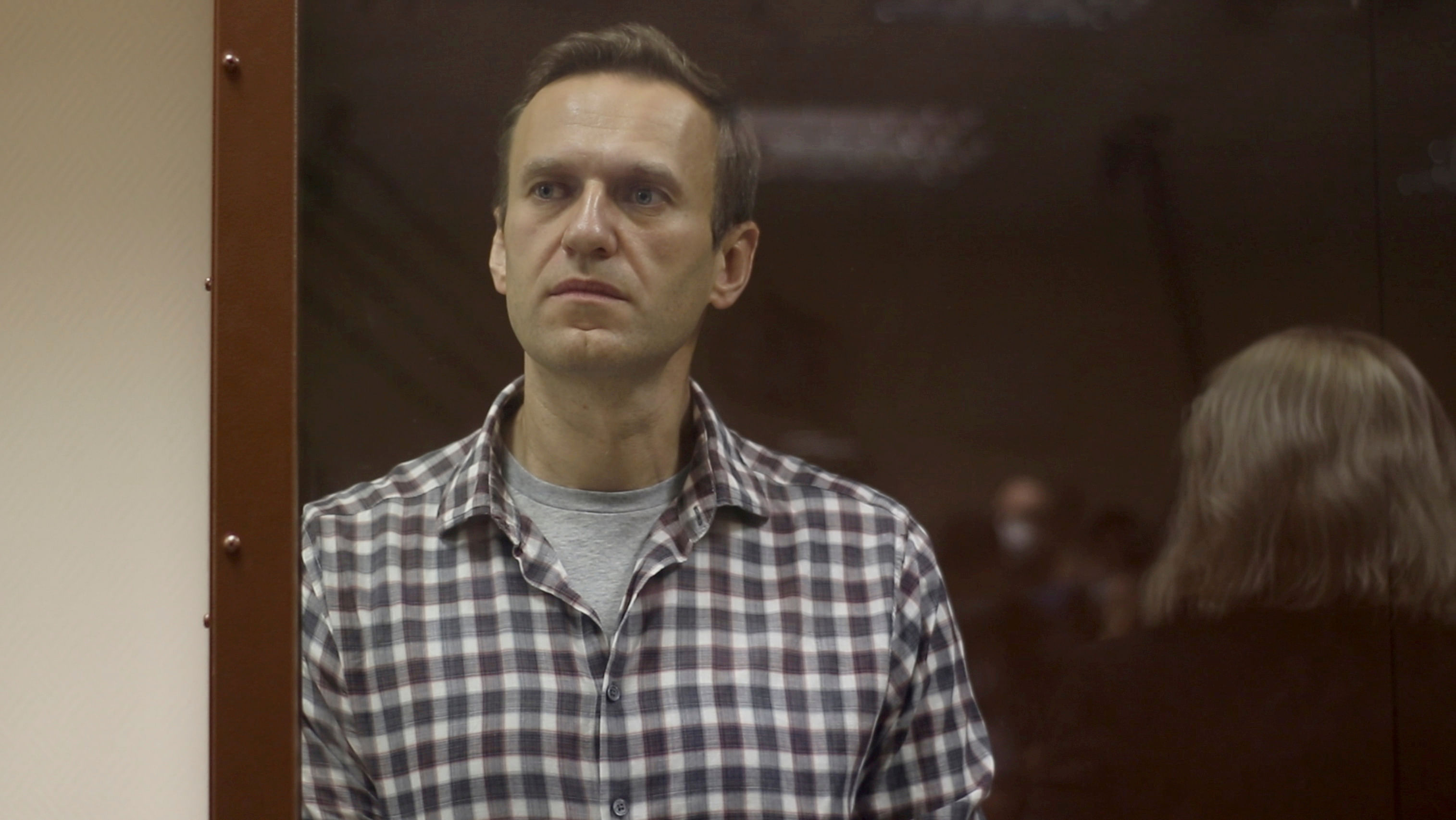 Kremlin critic Alexei Navalny stands inside a defendant dock during a court hearing in Moscow, Russia, Russia February 20, 2021, in this still image taken from video. Credit: Babushkinsky District Court of Moscow/Handout via REUTERS