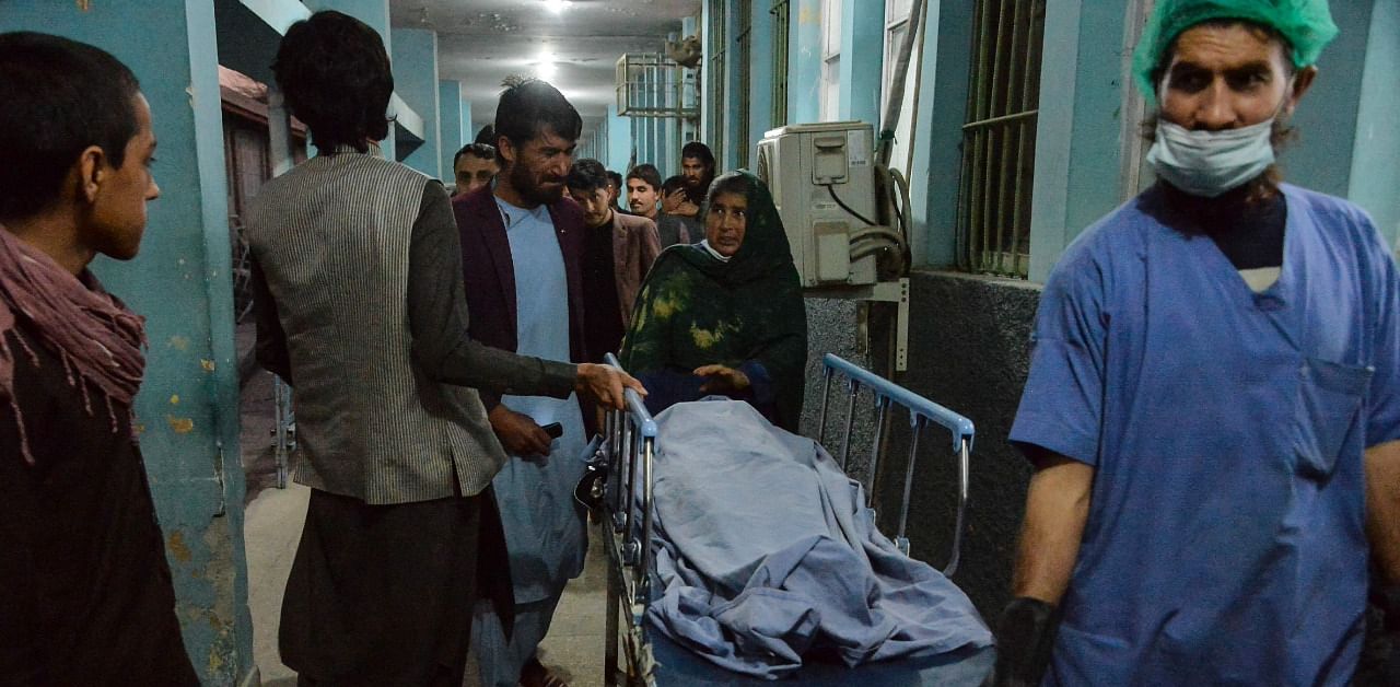 Hospital workers and relatives shift the body of one of the three female media workers. Credit: AFP Photo