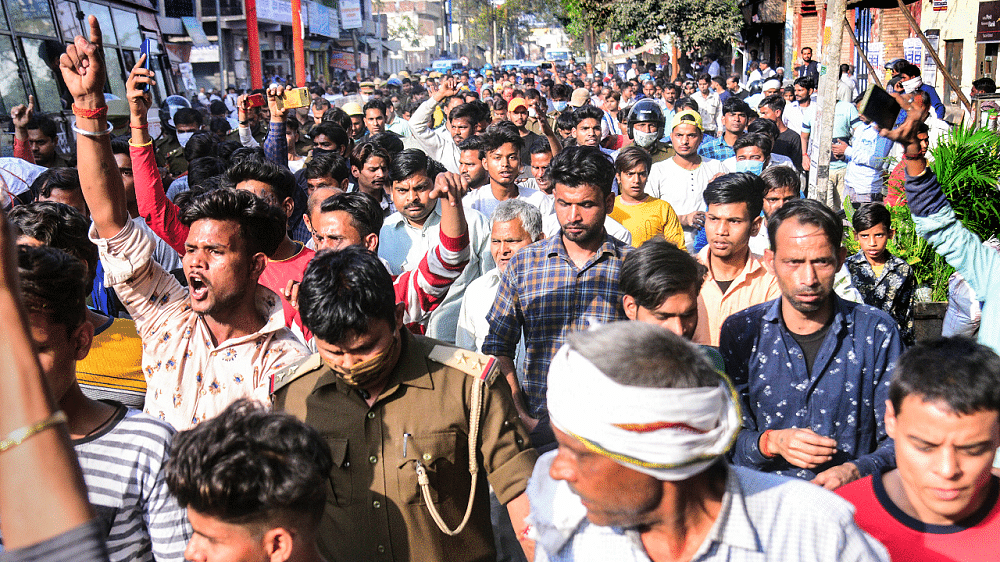 A large number of people stage a protest against the alledged murder of a 17-year-old Dalit girl, who was found dead at a field at Akrabad, in Aligarh. Credit: PTI Photo