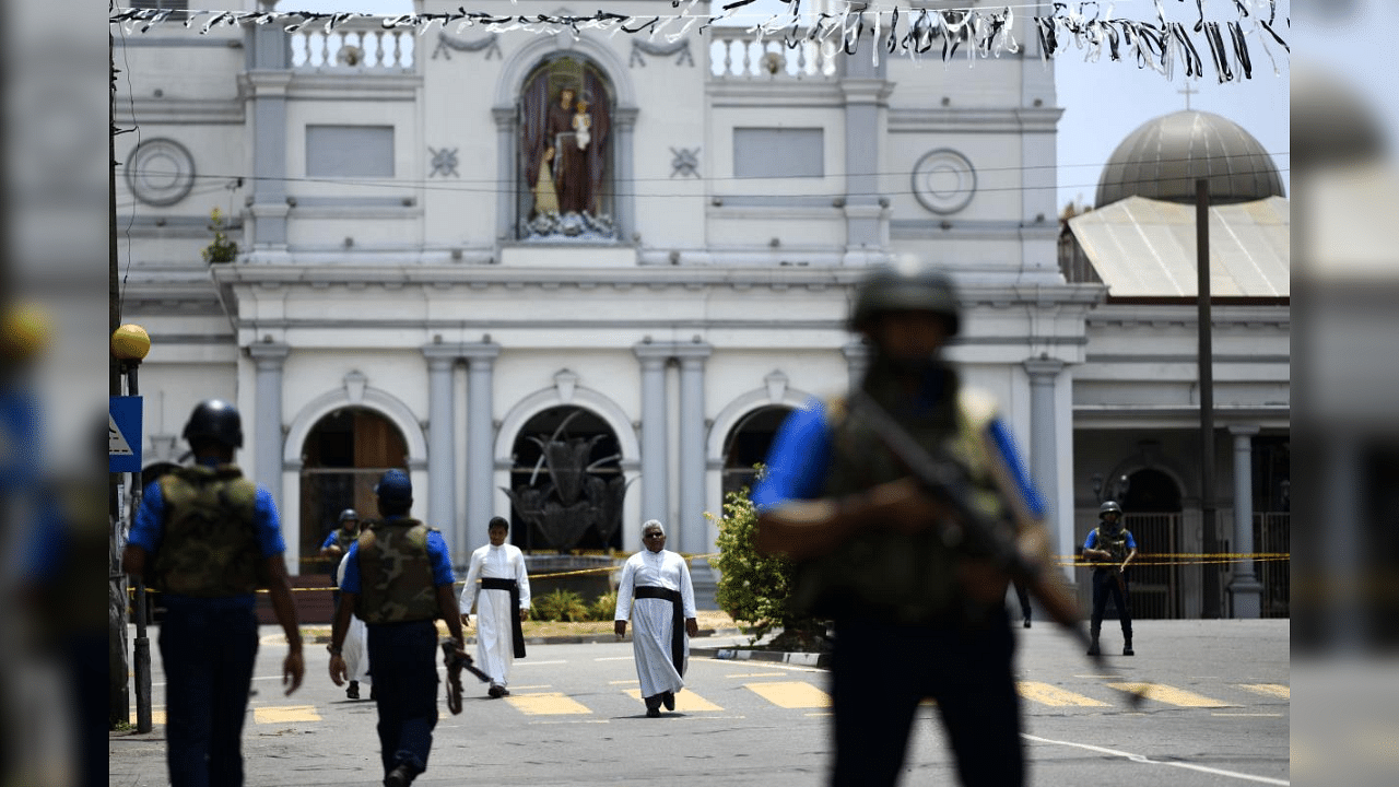 Priests walk on a blocked street as soldiers stand guard outside St. Anthony's Shrine in Colombo on April 25, 2019, following a series of bomb blasts targeting churches and luxury hotels on the Easter Sunday in Sri Lanka. Credit: AFP Photo