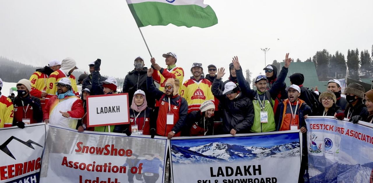 Participants wave the Tricolour during the march-past ceremony at the inaugural function of 2nd Khelo India National Winter Games, at the ski resort of Gulmarg. Credit: PTI Photo