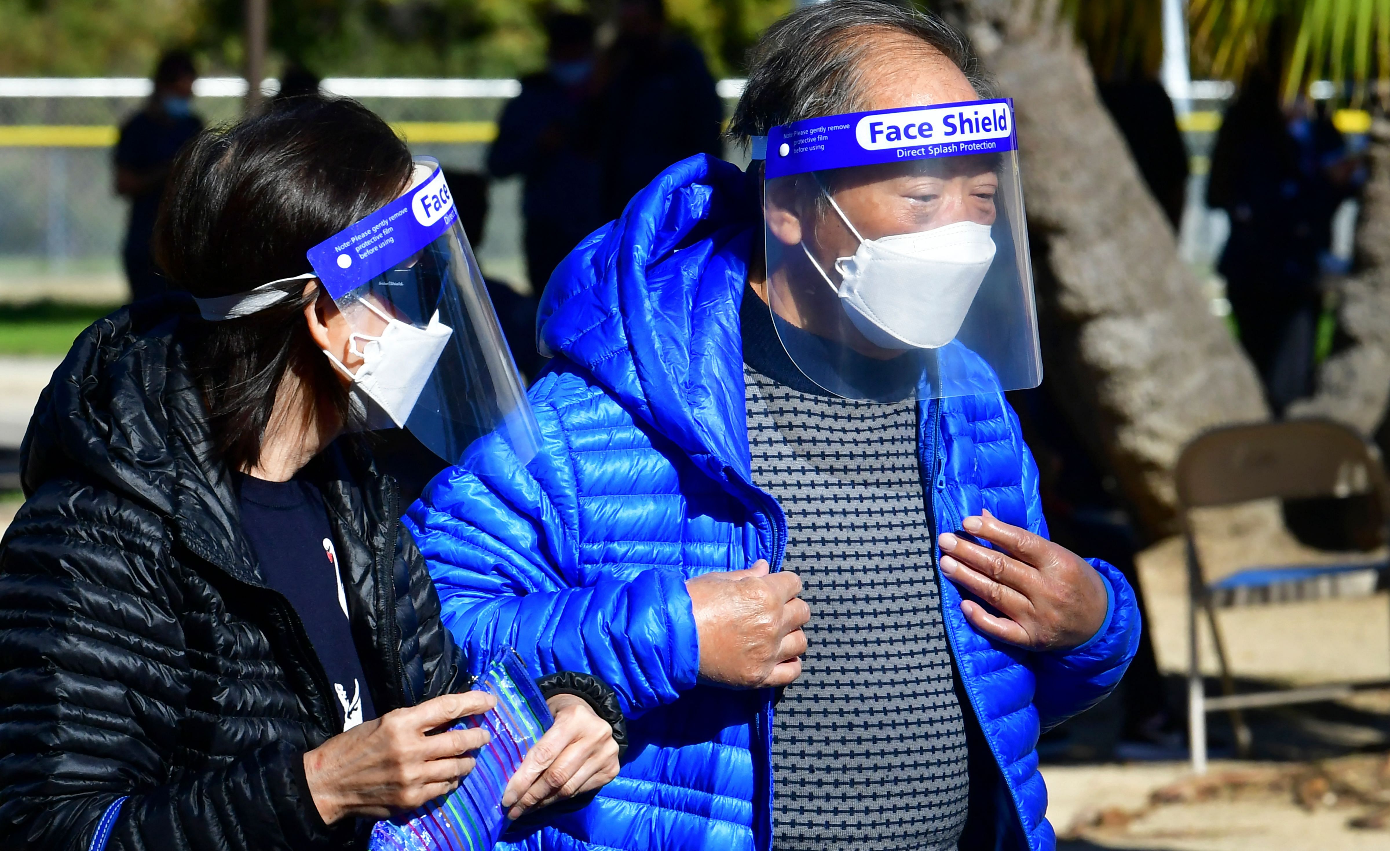 Elderly Asian Americans wear face shields and masks at a Covid-19 vaccination site in Los Angeles, California on February 23, 2021. - City-wide vaccination sites reopened after a temporary shutdown due to inclement weather which affected transportation of the vaccine. A California program meant to improve availability of Covid-19 vaccines in underserved minority communities is reportedly being misused by people in wealthier areas of Los Angeles, grabbing appointments reserved for residents of Black and Latino neighborhoods, according to a Los Angeles Times report on February 22. Credit: AFP Photo