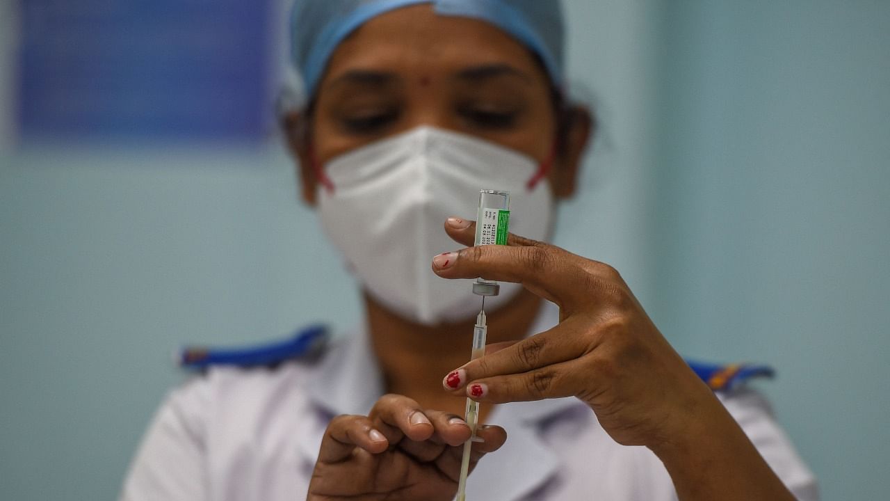 A health worker prepares to administer a dose of a Covid-19 coronavirus vaccine to a senior citizen. Credit: AFP Photo