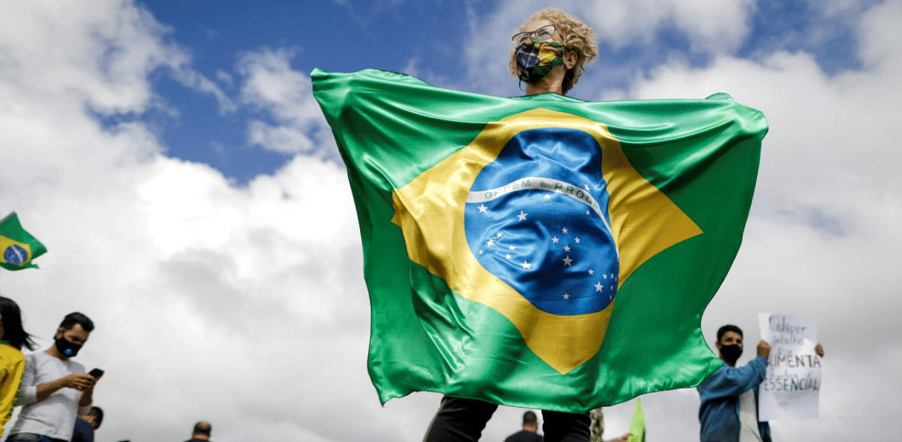 A woman holds a Brazilian flag during a protest called by businessmen against the lockdown decreed by Brasilia's Governor Ibaneis Rocha to slow down the rate of the coronavirus disease (COVID-19) contagion in Brasilia, Brazil. Credit: Reuters photo. 