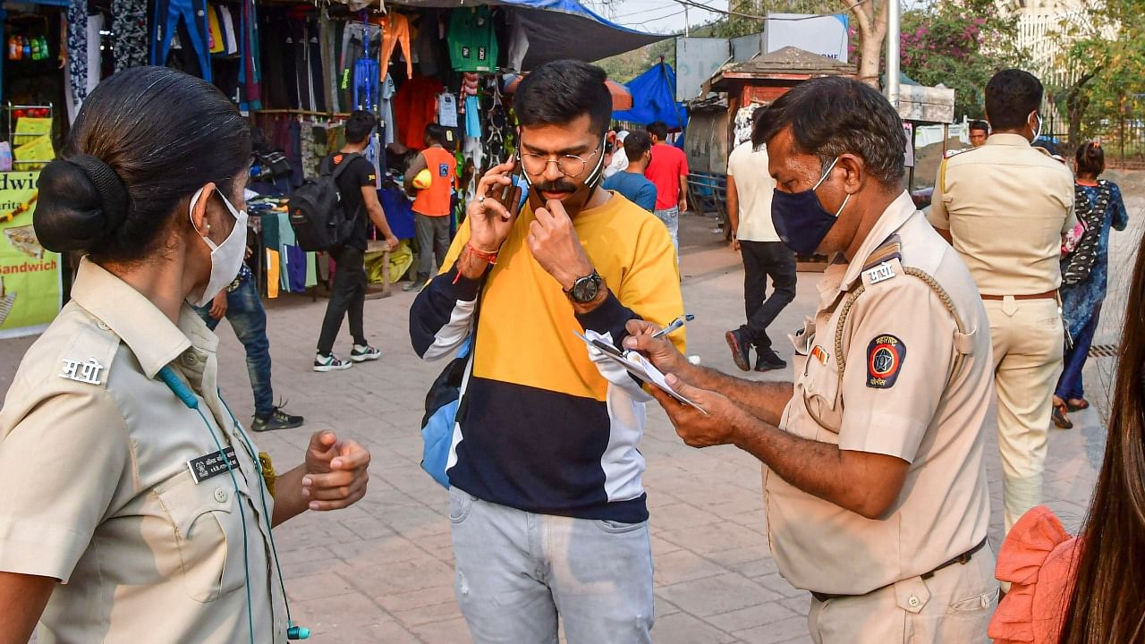 Police officials penalise a commuter for not wearing masks, amid rise in coronavirus cases across Maharashtra, in Mumbai. Credit: PTI File Photo