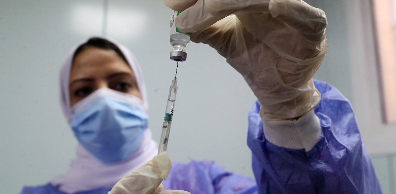 A healthcare worker holds a syringe and vaccine vial in Egypt. Credit: Reuters Photot