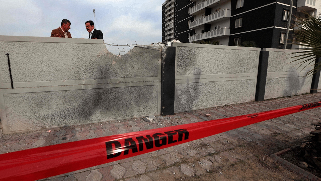 Two men stand near the scene of a rocket attack targeting Arbil the previous night, the first time in nearly two months that Western military or diplomatic installations have been targeted in Iraq. Credit: AFP Photo