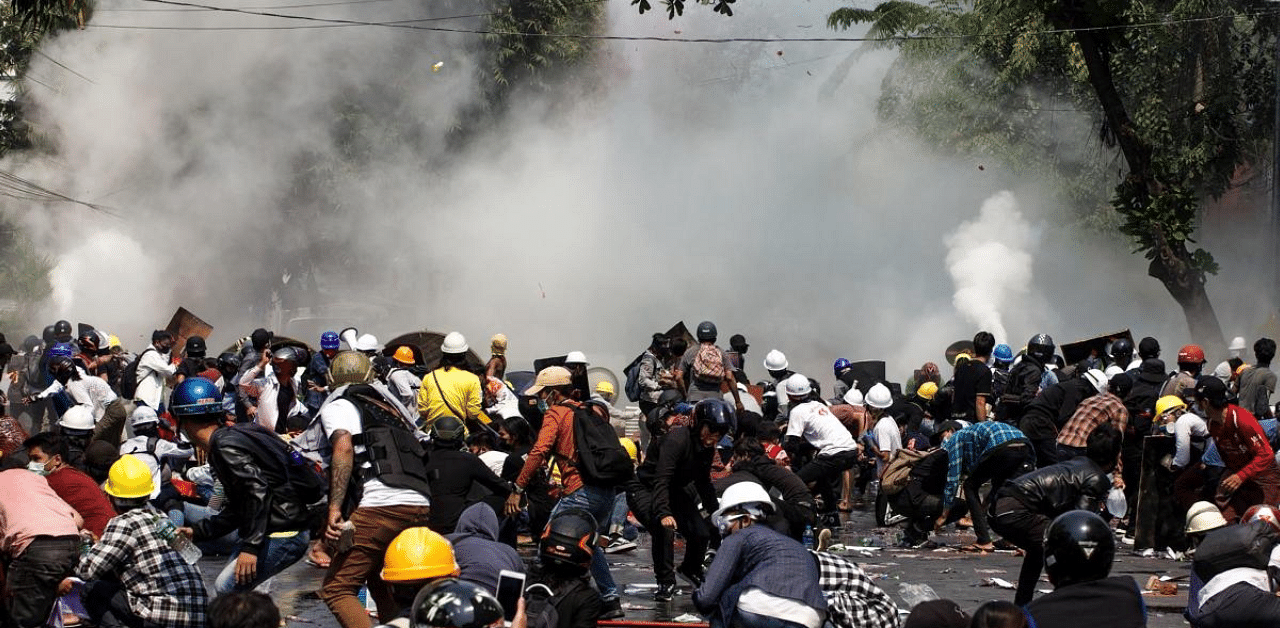 Protesters react after police fired tear gas during a demonstration against the military coup in Mandalay. Credit: AFP Photo