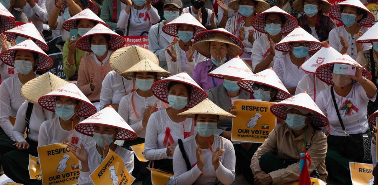 Myanmar women in traditional hat occupy a street during a demonstration against the military coup in Mandalay. Credit: AFP file photo. 