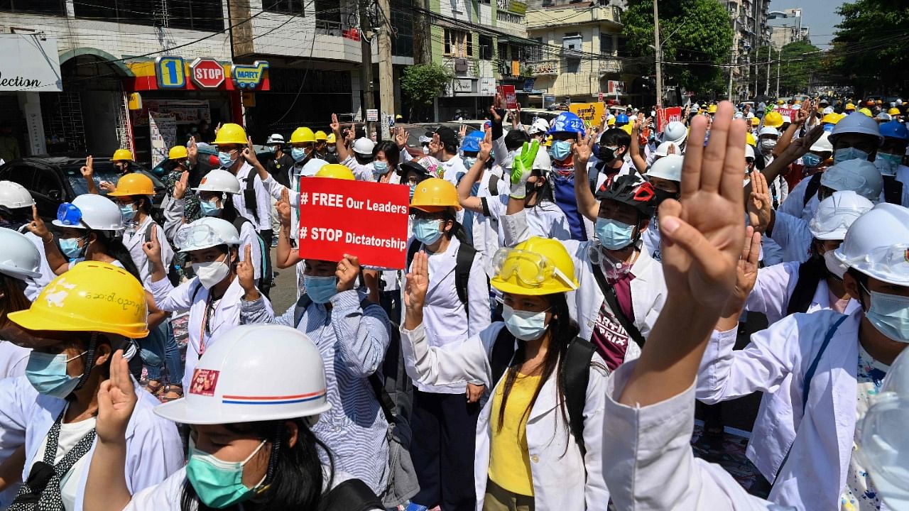 Medical personnel and students hold up the three finger salute during a demonstration against the military coup in Yangon on March 5, 2021. Credit: AFP Photo