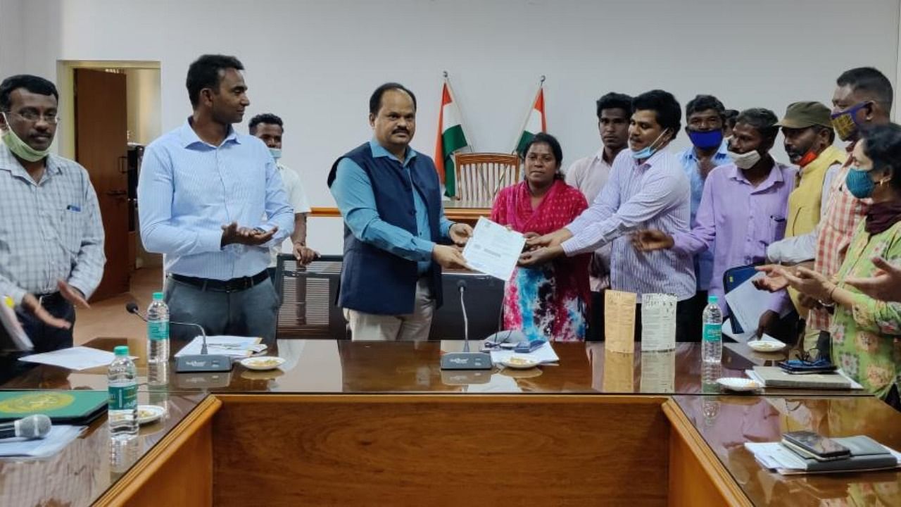 The Karnataka Maharishi Valmiki Scheduled Tribes Development Corporation presents a certificate for Rs 30 lakh for Soligas Producers Company, to Deputy Commissioner M R Ravi in Chamarajanagar on Friday. Credit: DH Photo.