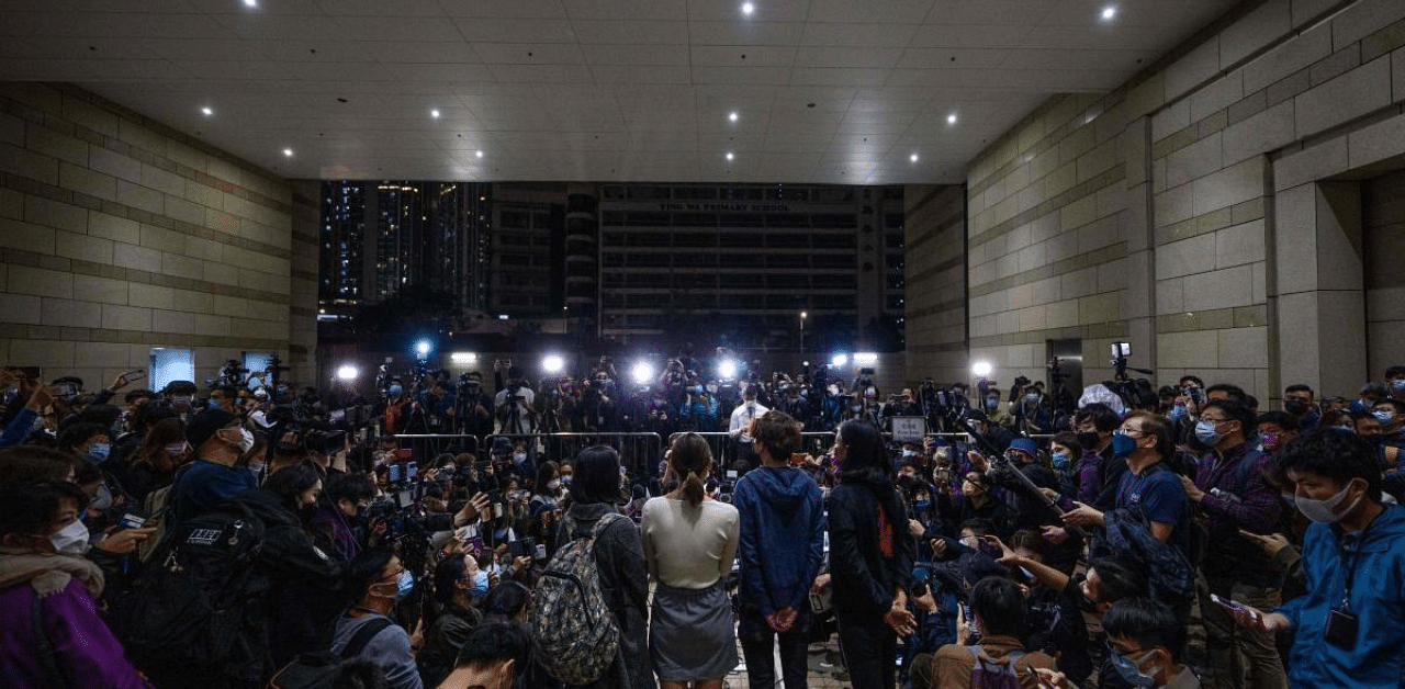 Pro-democracy supporters (C) speak to the media outside the West Kowloon Court in Hong Kong. Credit: AFP Photo