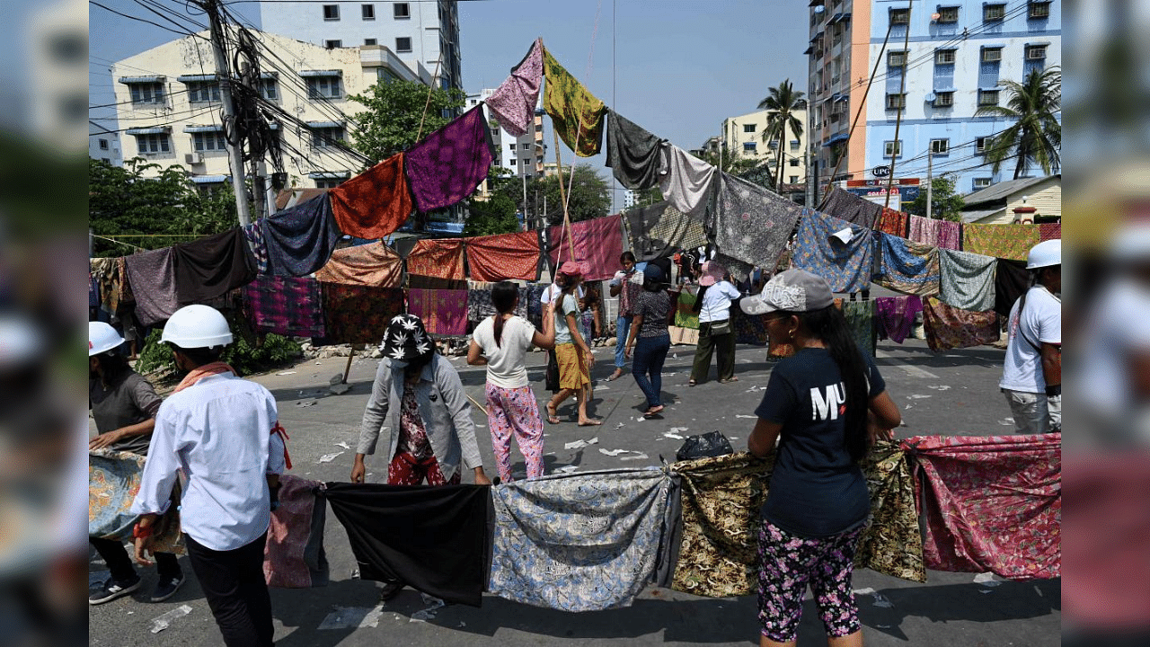 In this file photo taken on March 3, 2021, protesters make a barricade across a road with longyi, a traditional clothing widely worn in Myanmar, during a demonstration against the military coup in Yangon. Credit: AFP Photo