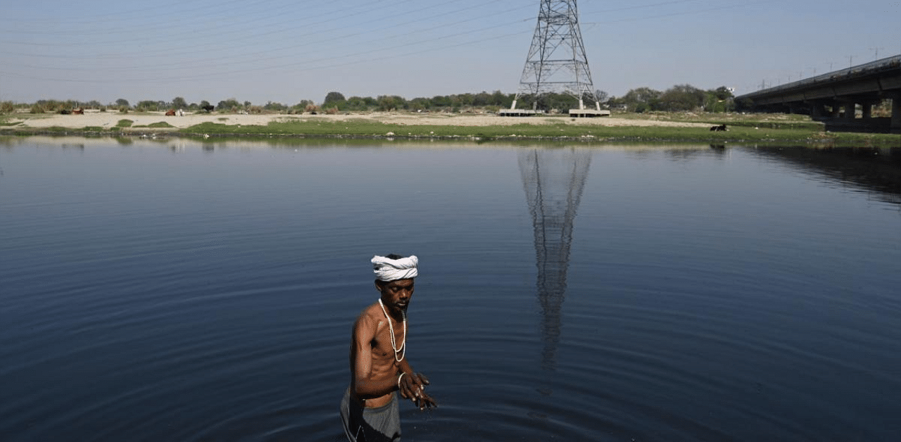 A man looks for valuables in the polluted Yamuna River in New Delhi. Credit: AFP photo. 
