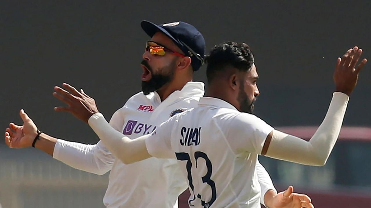 India's captain Virat Kohli and Mohammed Siraj celebrate the wicket of England's Joe Root. Credit: Reuters.