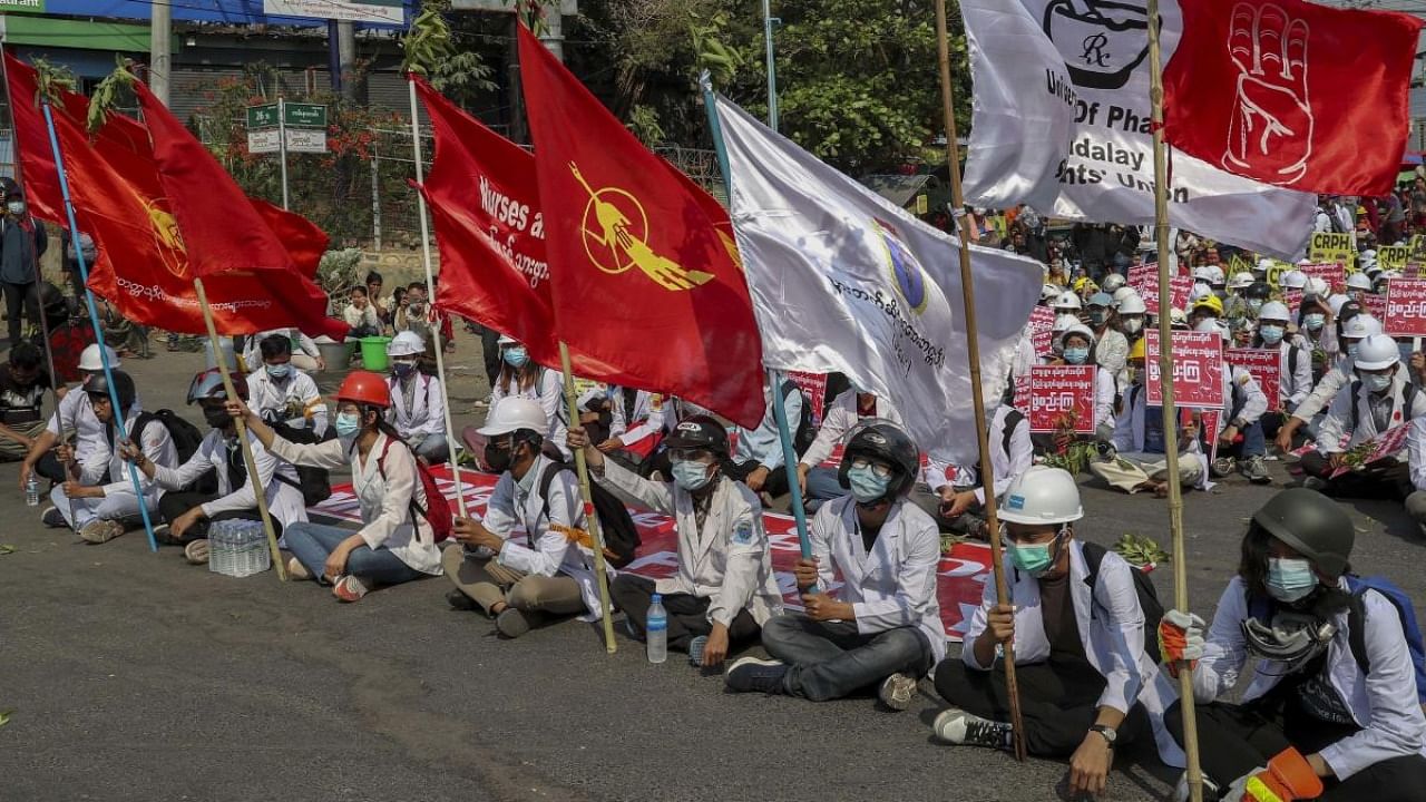 Medical students display flags of the National League for Democracy party during an anti-coup demonstration in Mandalay, Myanmar. Credit: AP/PTI.