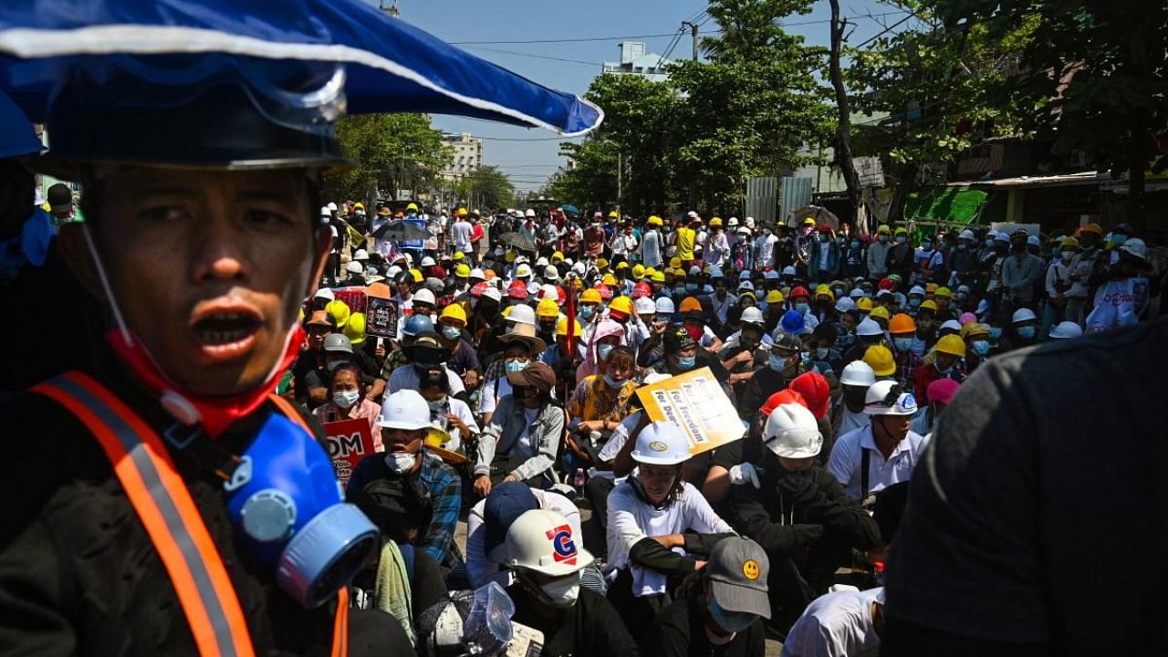 Protesters wearing protective equipment take part in a demonstration against the military coup in Yangon. Credit: AFP.