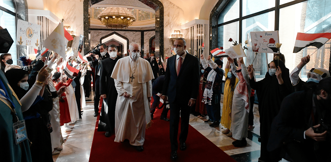 Iraqi Prime Minister Mustafa Al-Kadhimi walks with Pope Francis upon his arrival at Baghdad International Airport, in Baghdad. Credit: Reuters Photo